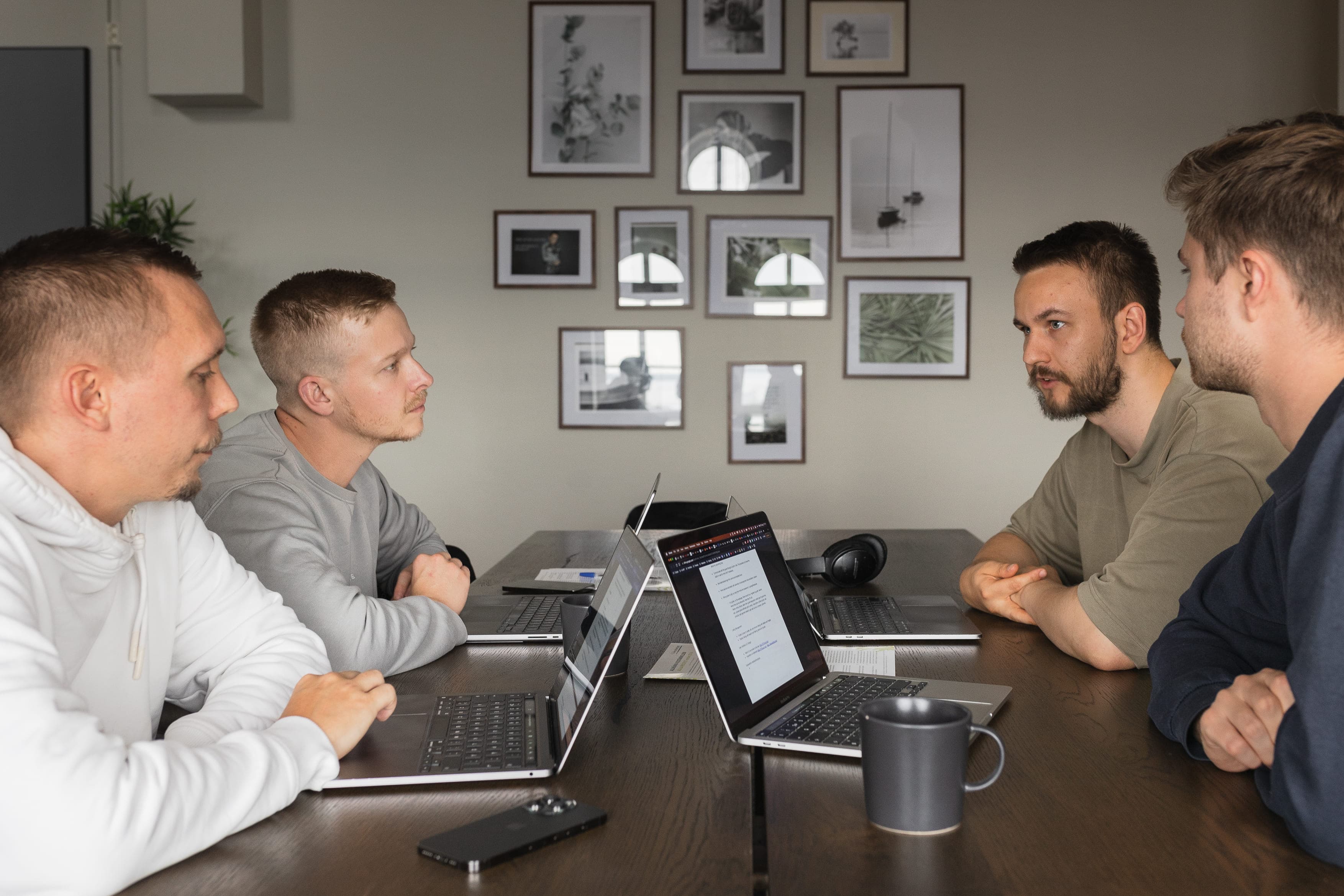 Four of the Flowbic guys are sitting at a table having a meeting together